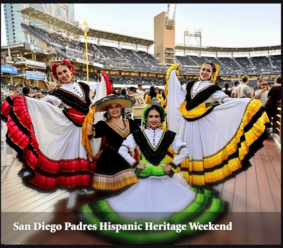 Four women in vibrant traditional dresses pose joyfully at the San Diego Padres Hispanic Heritage Weekend, celebrating culture and community.